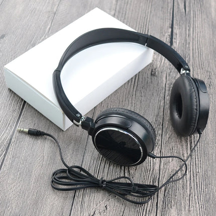 Black headphones with a cable on a wooden surface