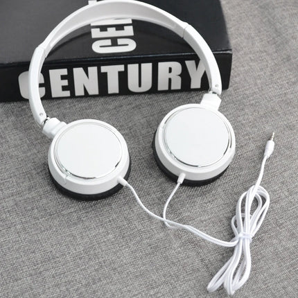 White headphones on a gray surface with a 'Century' book in the background